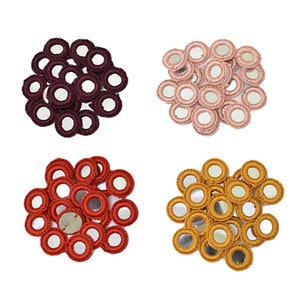 Puede incluir: Surtido de 20 pequeños espejos redondos con ribete de ganchillo en cuatro colores: burdeos, melocotón, naranja y amarillo mostaza.