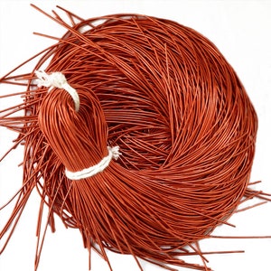 May include: A spool of orange leather cord, approximately 91 metres long, ideal for jewellery making, leather crafting, and other DIY projects.