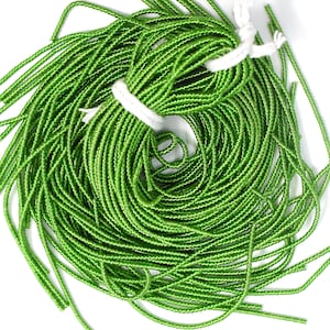 May include: A spool of bright green satin cord, wound tightly and tied with a white string.