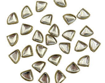 May include: A collection of 25 silver-toned, faceted, teardrop-shaped embellishments with gold-toned metal settings.