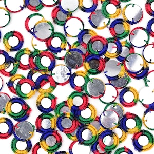 Puede incluir: Surtido de adornos redondos bordados de colores con un centro de espejo. El adorno está hecho de hilo verde, rojo, azul y amarillo.
