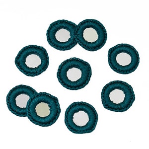 May include: Ten teal crocheted circles with small round mirrors in the center.