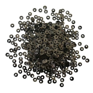 May include: A large pile of small, round, black sequins. The sequins are scattered on a white background.