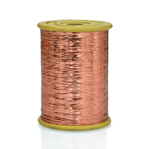 Puede incluir: Una bobina de hilo metálico de color cobre enrollado en una bobina de plástico beige.