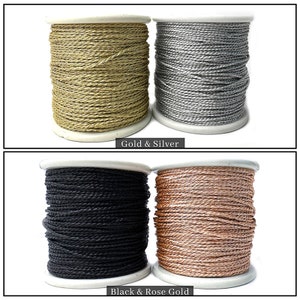 May include: Four spools of decorative cord in gold, silver, black, and rose gold. The spools are labelled "Gold & Silver" and "Black & Rose Gold". The cord is tightly wound on white spools, suitable for crafts and jewellery making.