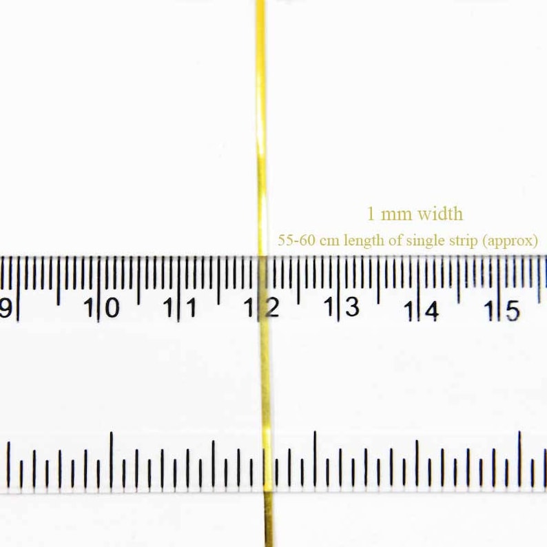 May include: A close-up of a gold ribbon measuring 1 mm wide and 55-60 cm long. The ribbon is placed on a ruler for size reference.