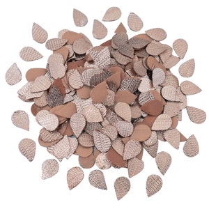 Pode incluir: Um grande monte de lantejoulas em forma de lágrima de cor ouro rosa. As lantejoulas são feitas de um material brilhante e metálico e têm uma superfície texturizada.