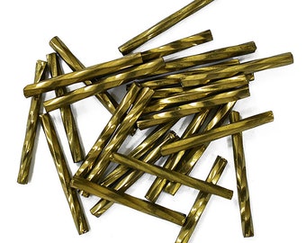 May include: A pile of gold-colored twisted glass beads. The beads are about 1 inch long and have a slightly textured surface.