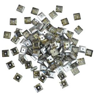 May include: A collection of square, faceted rhinestones in shades of grey and brown. Each rhinestone has a small square hole in the centre. The rhinestones are scattered across a white background, creating a sparkling effect.