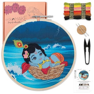 May include: Embroidery kit featuring a blue and orange cartoon figure in a woven basket on a blue background. The kit includes embroidery floss, scissors, needles, and a wooden hoop. The box has the text "pick n MAKE Joy of embroidery".