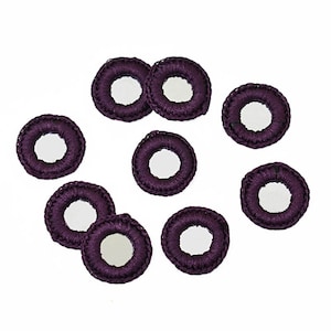 May include: Ten purple crocheted circles with small mirrors in the centre.