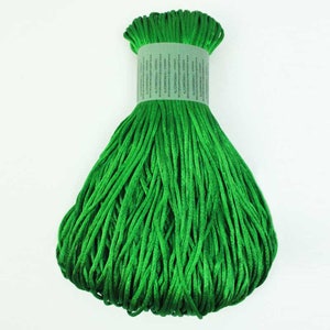 May include: A spool of bright green satin cord. The cord is tightly wound and ready for crafting projects.