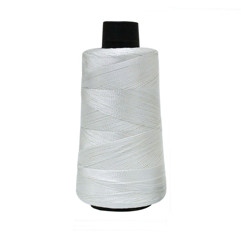 May include: A spool of white thread with a black plastic top.