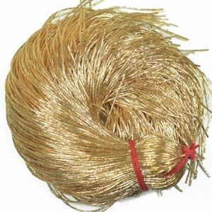 May include: A large spool of gold metallic cord. The cord is tightly wound and has a shiny, metallic finish.