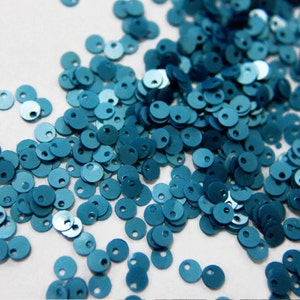Puede incluir: Una dispersión de lentejuelas azul turquesa, un material de artesanía popular para embellecer la ropa, los accesorios y los proyectos de decoración del hogar.
