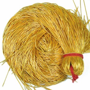 Puede incluir: Una gran bobina de alambre de color dorado, atada con una cuerda roja.