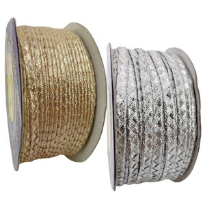 May include: Two spools of braided trim, one gold and one silver. The trim is woven with a diamond pattern and has a metallic sheen.