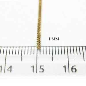 May include: Close-up of a gold chain, measuring 1 mm in width, against a white background.