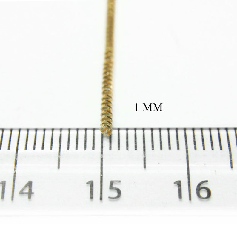 May include: Close-up of a gold chain, measuring 1 mm in width, against a white background.