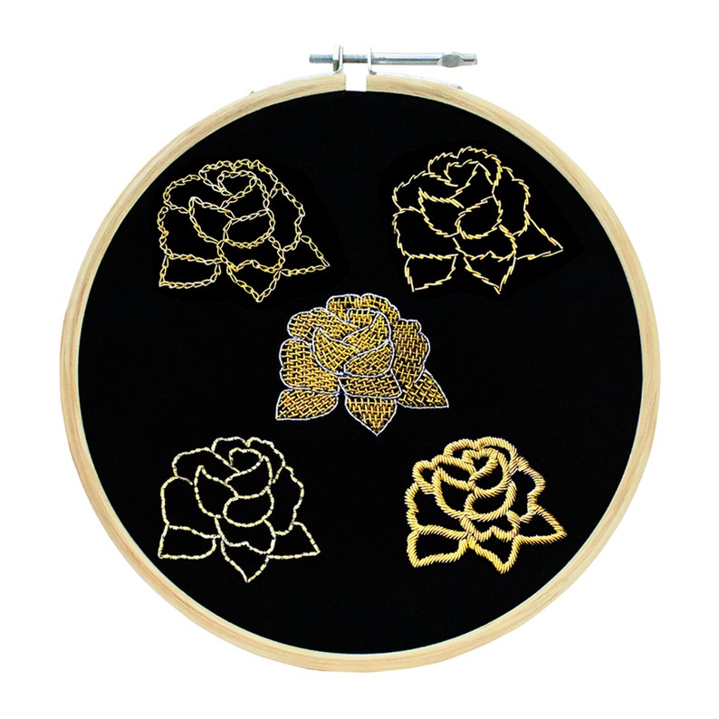 May include: Five gold embroidered roses on a black fabric background in a wooden embroidery hoop.