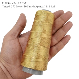 May include: A gold metallic thread spool, 5 inches by 11.5 inches, with 270 meters or 300 yards of thread.