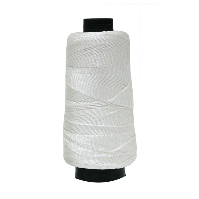 May include: A white spool of thread with a black plastic bobbin.