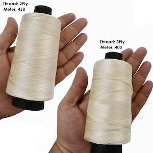 May include: Two spools of white thread, one labeled "Thread: 2Ply Meter: 450" and the other labeled "Thread: 3Ply Meter: 400".