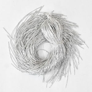 May include: A large spool of silver metallic thread. The thread is tightly wound and has a shiny, reflective finish.