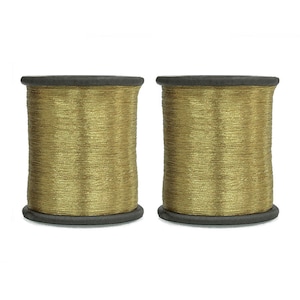 May include: Two spools of gold metallic thread, each wound on a black plastic bobbin.