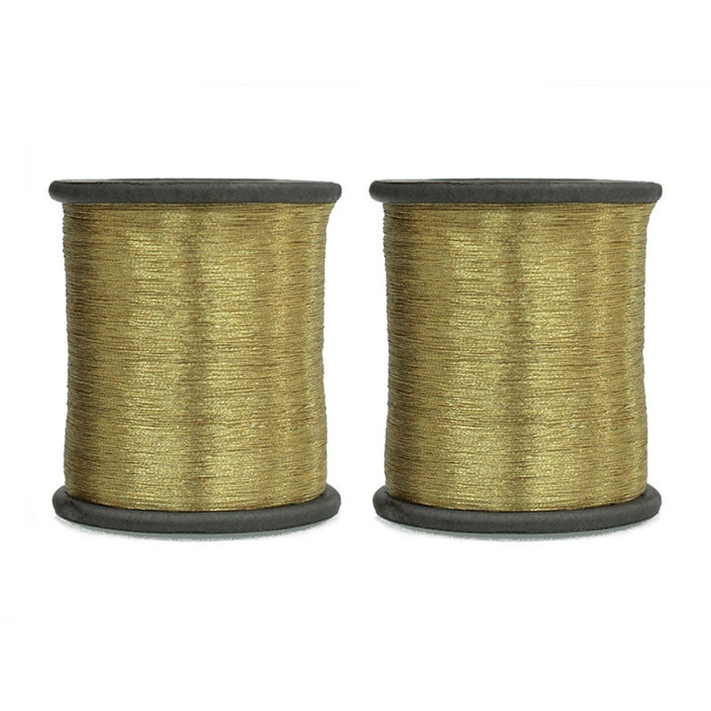 May include: Two spools of gold metallic thread, each wound on a black plastic bobbin.