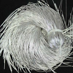 May include: A bundle of silver-coloured wire, tightly bound in the centre with a white string. The wires are thin and flexible, radiating outwards from the centre. The background is a solid black.