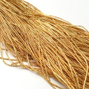 May include: A close-up of a pile of gold metallic cord. The cord is thin and shiny, and it is perfect for crafting projects.