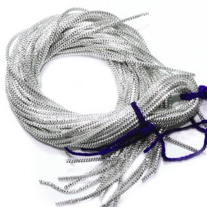 May include: A spool of silver-colored, sparkly, chain-like trim. The trim is wound around itself in a circle and tied with a purple ribbon.