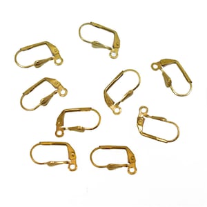 May include: A collection of gold-colored leverback earring findings. Each finding features a hinged design with a curved wire loop and a lever closure. The findings are designed for jewelry making and earring components.