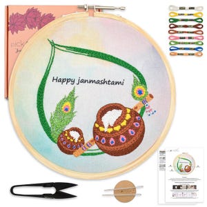 May include: Embroidery kit featuring a wooden hoop with a colorful design and the text "Happy janmashtami". The design includes a peacock feather and pots. Includes embroidery floss, scissors, and instructions.