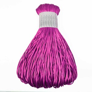 May include: A spool of bright magenta satin cord, perfect for crafting projects.