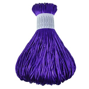 May include: A bundle of vibrant purple craft cord, tightly wrapped with a white label. The cord is made of numerous thin strands, creating a textured appearance. Ideal for various crafting projects, the cord's rich color adds visual appeal.
