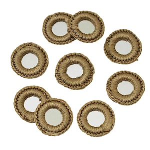 Op de afbeelding: Een verzameling goudkleurige, cirkelvormige decoratieve elementen. Elk element heeft een centrale spiegel omgeven door een geweven, getextureerde rand. De elementen zijn geplaatst tegen een witte achtergrond, die hun reflecterende oppervlakken benadrukt.
