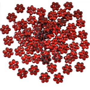 May include: A large pile of red, sparkly, flower-shaped embellishments. These are great for adding a touch of sparkle to crafts, cards, and other projects.