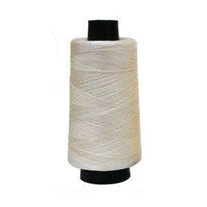 May include: A spool of white thread with a black plastic bobbin.