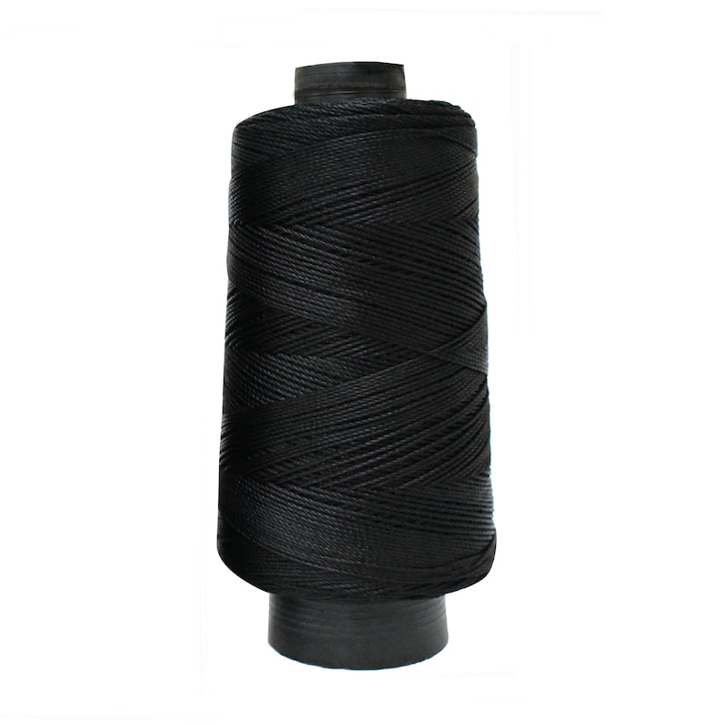 May include: A spool of black thread.