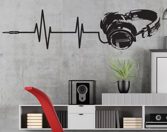 May include: A red chaise lounge with a white shelf unit behind it. The shelf unit has a speaker, books, and a framed picture. A black and white graphic of headphones with a heartbeat line and a cord is on the wall behind the shelf unit.