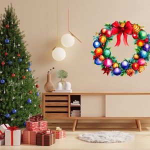 Puede incluir: Una corona de Navidad con adornos rojos, verdes, azules, dorados y plateados. La corona está colgada en una pared beige sobre un armario de madera con un árbol de Navidad en primer plano.