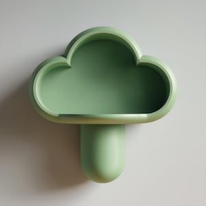 May include: A sage green cloud-shaped wall shelf. The shelf has a rounded, three-dimensional design with a flat bottom and a cylindrical support. The shelf is mounted on a light gray wall.