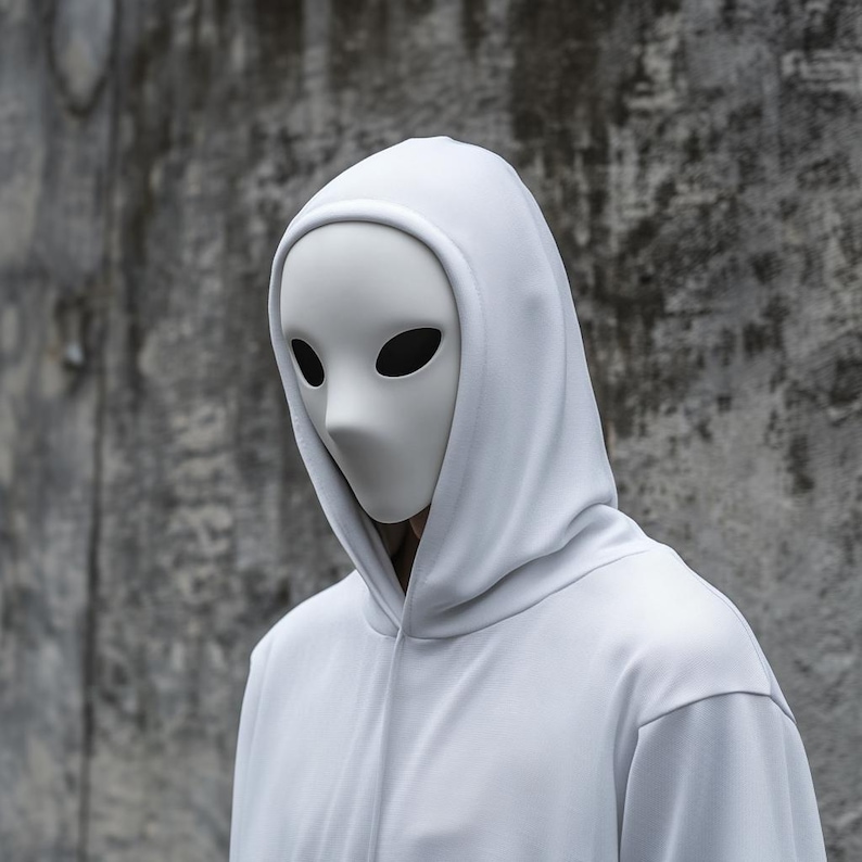 May include: A person wearing a white hooded sweatshirt with a white mask covering their face. The mask has two black eye holes.