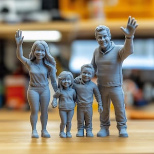 Op de afbeelding: Een grijze 3D-geprinte familiefiguur, met een zwaaiende vrouw, een zwaaiende man en twee kinderen. De figuren dragen vrijetijdskleding en lachen. De familie staat dicht bij elkaar, wat wijst op een hechte band.