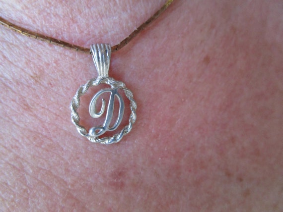 Initial D in cursive in a etched bezel on a 18' i… - image 1