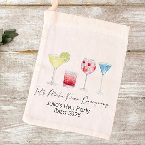 Peut inclure: Un sac en toile blanc avec une illustration colorée de quatre cocktails. Le texte "Let's Make Pour Decisions" est écrit en cursive. En dessous du texte se trouve "Julia's Hen Party Ibiza 2025".