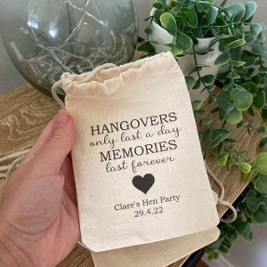 May include: A white cotton drawstring bag with the text "Hangovers only last a day MEMORIES last forever" and a black heart. The bag also has the text "Clare's Hen Party 29.4.22".