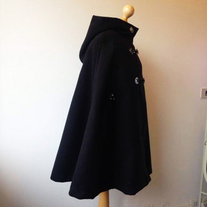 May include: Black hooded cape with a long, flowing design and silver button closures.